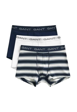 Trois paires de boxers pour hommes empilées, une bleu marine, une blanche et une rayée bleu marine et blanc, toutes avec une ceinture avec le logo GANT.