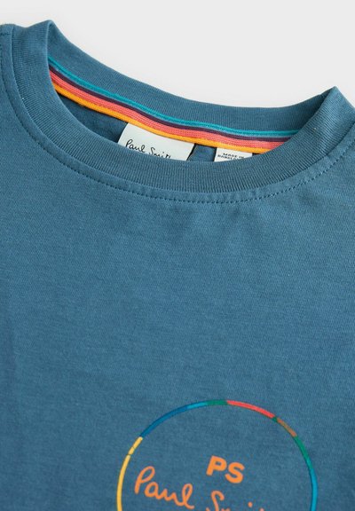Modrá bavlněná tričko s kulatým logem s "PS" a "Paul Smith" v oranžové, ohraničené vícebarevným kruhem. Design s kulatým výstřihem.