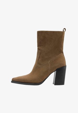 Rjavi antilopski gležnjar z ostro konico in blok peto. Poudarjen z všitimi detajli in z zanko na peti za enostavno obuvanje.