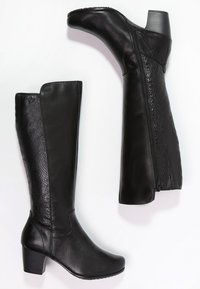 Botas negras hasta la rodilla hechas de cuero liso y texturizado, con un bajo tacón cuadrado y cierre lateral con cremallera para facilitar su uso.