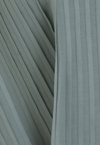 Tela con pliegues en azul grisáceo claro, con rayas verticales y una textura suave. El material parece ligero y liso con un brillo sutil.