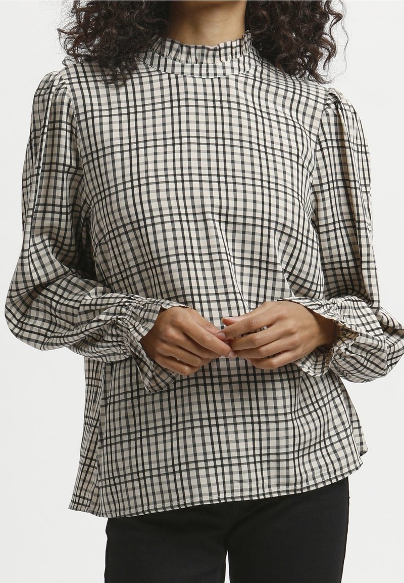 Kariertes Bluse in Beige und Schwarz, mit einem hohen, gerafften Ausschnitt und Puffärmeln mit elastischen Bündchen. Der Stoff hat eine glatte Textur.
