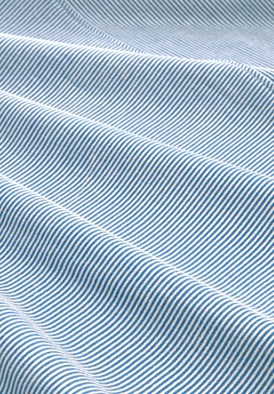 Blue and white striped fabric, featuring thin, even stripes on a soft, textured surface, draped in gentle waves.