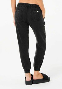 Sorte joggerbukser med elastisk talje, tekstureret stof og to baglommer. Benene har en tætsiddende pasform for et tapered look.