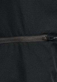 Tessuto nero con un delicato motivo a griglia, caratterizzato da una chiusura con zip orizzontale al centro. Texture liscia e dettagli di design minimal.