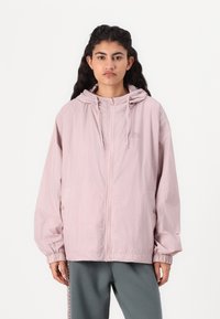 Lys rosa hettegenser med et teksturert rutemønster, frontglidelås, elastiske mansjetter og sidelommer. Ledig passform med et enkelt design.