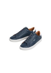 Zapatillas de cuero azul marino con suelas blancas, con diseño de cordones, forro interior en tono beige y sutil branding en el lateral.