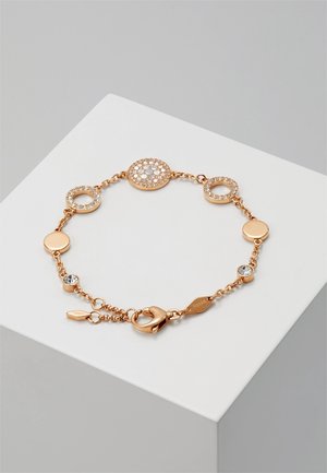 Bracelet délicat en or rose avec des breloques circulaires et rondes ornées de cristaux et une fermeture à mousqueton, présenté sur un socle blanc.