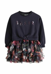 Marineblauer Sweatshirt mit "BAKER"-Logo und geknoteter Vorderseite, kombiniert mit einem schichtweisen Tüllrock mit floralem Muster.