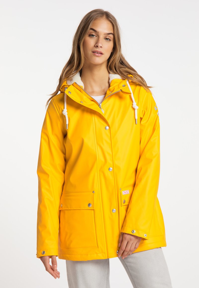 Giacca impermeabile gialla con zip frontale, cappuccio regolabile e bottoni a pressione. Presenta due tasche frontali e un rivestimento morbido.