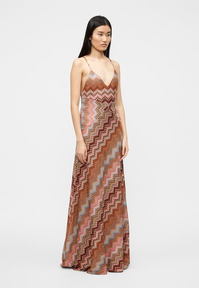 Μακρύ φόρεμα με ζικ-ζακ σχέδιο, με βαθύ V-λαιμόκοψη, λεπτές τιράντες και ρέουσα σιλουέτα σε γήινους τόνους καφέ, ροζ και μπλε.