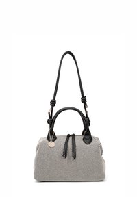 Borsa a strisce bianco e nero con forma rotonda, inserti in pelle nera, doppio manico e nappine decorative. Presenta un ciondolo dorato.