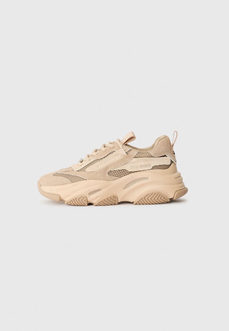 Baskets beiges épaisses avec panneaux en daim et en mesh, semelle épaisse texturée, design à lacets et languette au talon, marquées "Steve Madden" sur le côté.
