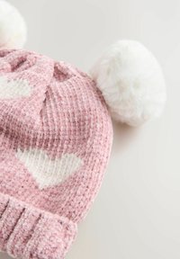 Bonnet en tricot rose texturé avec des motifs de cœurs blancs et deux pompons blancs duveteux sur le dessus. Bord côtelé à la base.