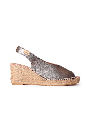 Metalni srebrni espadril s wedge peto, odprtim prstom, slingback obliko in pletenim jutenim podplatom. Ima kvačkane šive ob robu.
