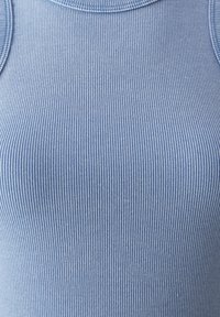 Camisola de alças azul claro com cintura canelada, apresentando um decote redondo e finas riscas verticais em um tecido suave e texturizado.