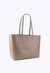 Borsa tote in pelle beige con due manici lunghi, forma rettangolare, texture liscia e dettagli di cucitura sottili.
