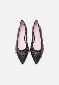 Ζευγάρι μαύρες μπαλαρίνες με μυτερή μύτη, γεωμετρικά μοτίβα με κοψίματα και μικρά φιόγκους στο πάνω μέρος, ροζ ανοιχτές εσωτερικές σόλες, σε προβολή από πάνω.