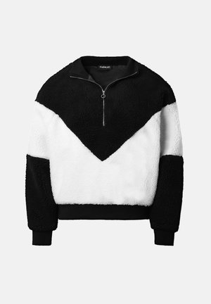 Bluza z przeciwległymi blokami kolorów wykonana z miękkiego polaru. Posiada czarny kołnierz, półzamek oraz wzór w kształcie cyklicznego zygzaka w czerni i bieli, a także ściągacze przy mankietach.