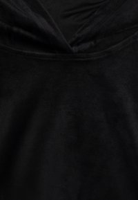 Black velvet top featuring a cowl neck design. The fabric appears soft and smooth with a subtle sheen, emphasizing its rich texture.