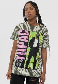 Green tie-dye t-shirt featuring a graphic print of a person in black and white with pink and green accents and text reading "TUPAC."