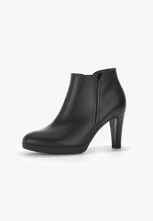 Zwarte leren enkelboot met een gladde afwerking, ronde neus en een 10 cm hoge stilettohiel. Bevat zijsplitten voor eenvoudig aan- en uittrekken.