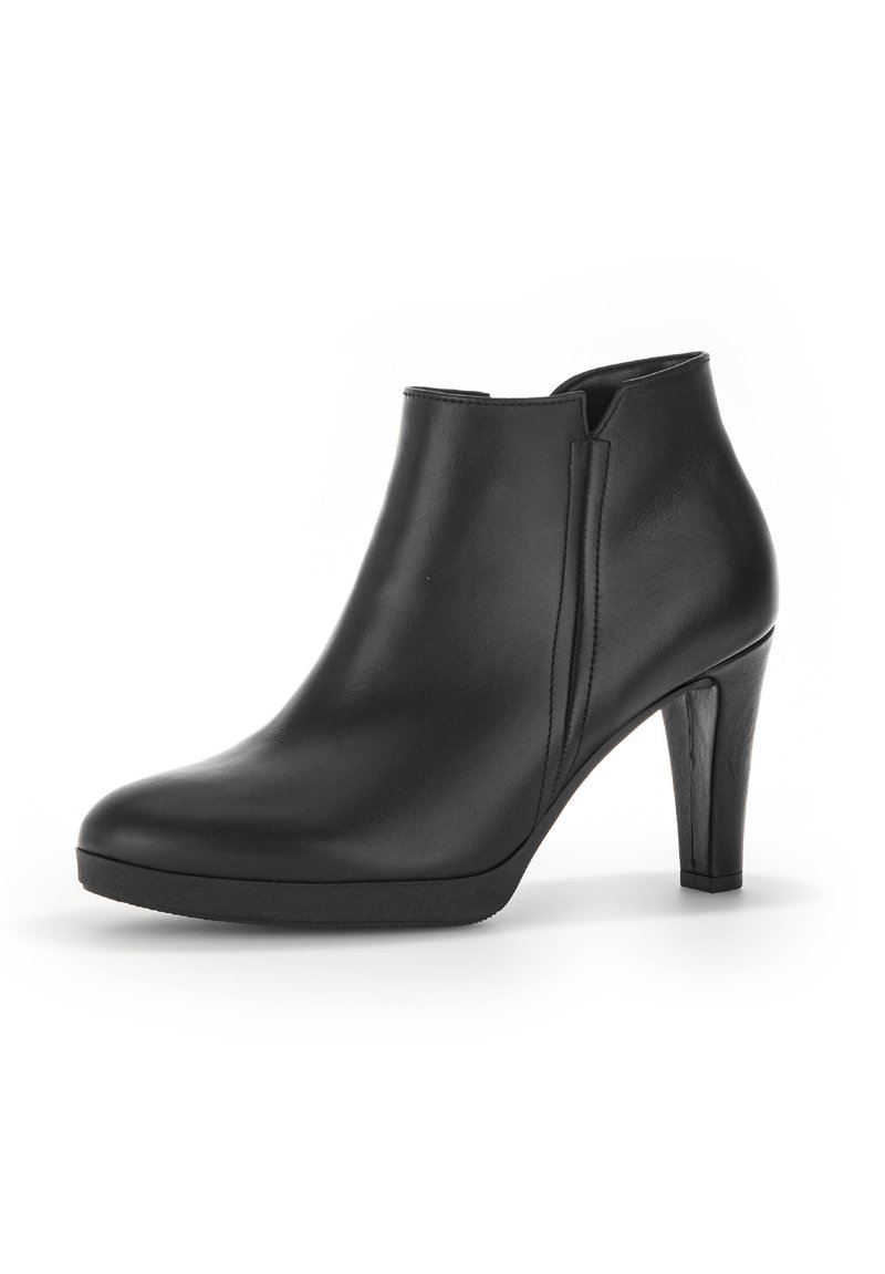 Bottine en cuir noir avec une finition lisse, bout arrondi et un talon aiguille de 10 cm. Présente des fentes latérales pour un enfilage facile.