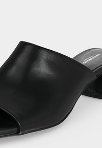 Μαύρο δερμάτινο σανδάλι slide με ανοιχτό δάχτυλο και φαρδιά επάνω επιφάνεια, επίπεδη σόλα και λογότυπο "Vagabond" στην εσωτερική σόλα.