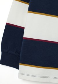 Maglietta a maniche lunghe color navy con righe orizzontali bianche, bordeaux e oro. Realizzata in morbido cotone, con polsini a costine e orlo dritto.