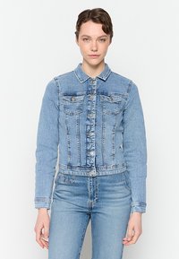 Ljusblå denimjacka med krage, framknäppning med knappar, två bröstfickor och en kort design med urblekta accenter.