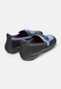 Schwarz-blaue Lederschuhe mit grünen Akzenten und dekorativen Blumen oben, von hinten auf einem weißen Hintergrund betrachtet.