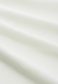Zacht, soepel wit materiaal met een lichte glans, met subtiele plooien en een uniforme textuur, ideaal voor kleding of stoffering.