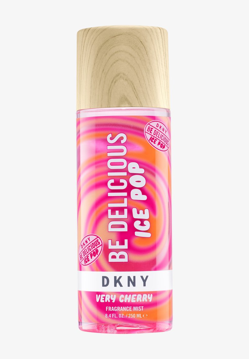 Flacon de brume parfumée avec un bouchon en bois, étiqueté "Be Delicious Ice Pop", "DKNY" et "Very Cherry" avec un motif tourbillonnant rose et orange.