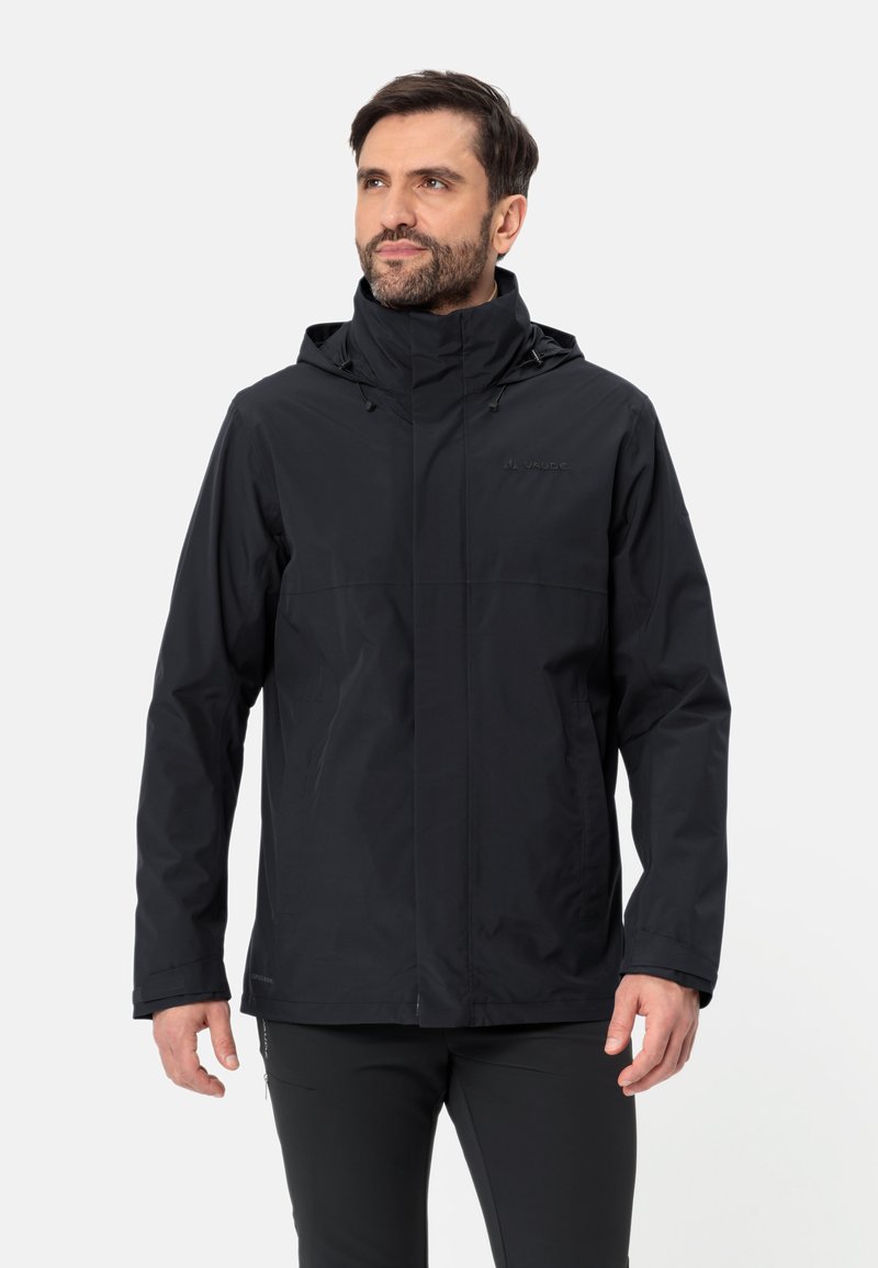Giacca nera impermeabile con cerniera anteriore, cappuccio regolabile e cordini. Presenta una superficie liscia e opaca e un design minimalista.