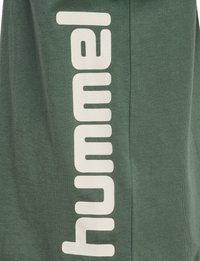 Grøn bomulds hoodie med en vertikal cremefarvet logotekst "hummel," der har en blød tekstur og et afslappet design.