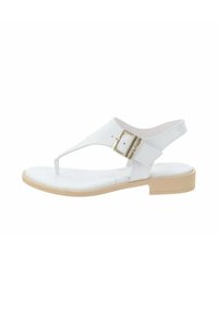 Sandalo bianco con design a infradito, fibbia regolabile, materiale superiore liscio e suola piatta di un leggero color beige. Caratterizza un'estetica minimalista.