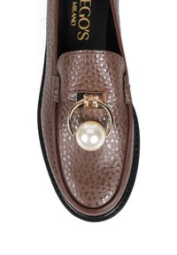 Brązowe skórzane mokasyny o teksturowym wykończeniu, z akcentem w postaci złotego pierścienia z białą perłą. Czarna podeszwa i subtelne detale podkreślają wykończenie.