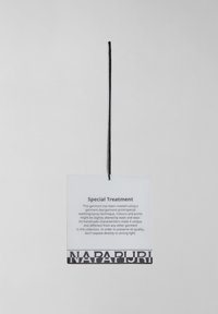 Průhledná visačka na zavěšení s černým textem, který obsahuje pokyny k údržbě. Obsahuje černou šňůrku a na spodní části se nachází tučný logo "NAPAPIJRI".