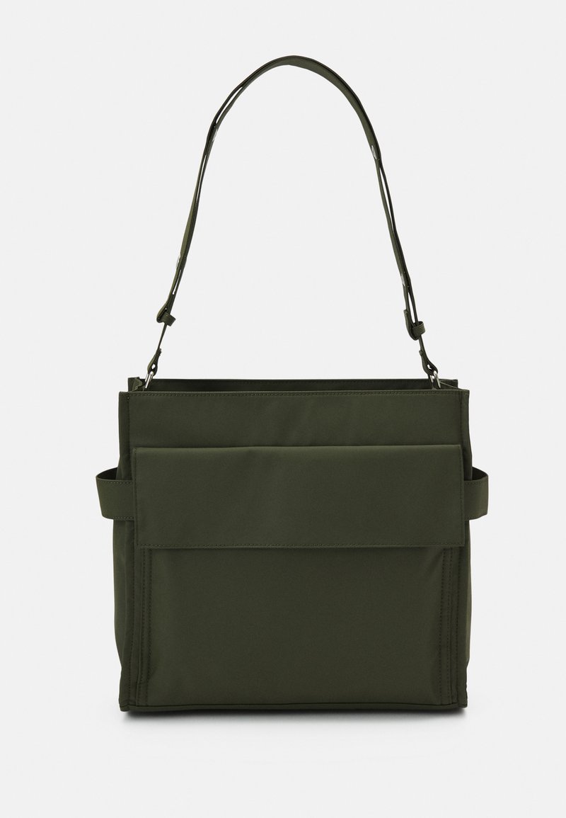 Geantă tote de culoare verde măslin, fabricată dintr-un material durabil, având o formă rectangulară, dotată cu o buzunar frontal cu clapetă și o curea de umăr ajustabilă.