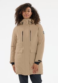 Beige eristetty parka, jossa on korkea kaulus, kaksi etutaskua ja vetoketjukiinnitys. Sisältää kiristysnauhan hupun ja pehmeän tekstuurin.