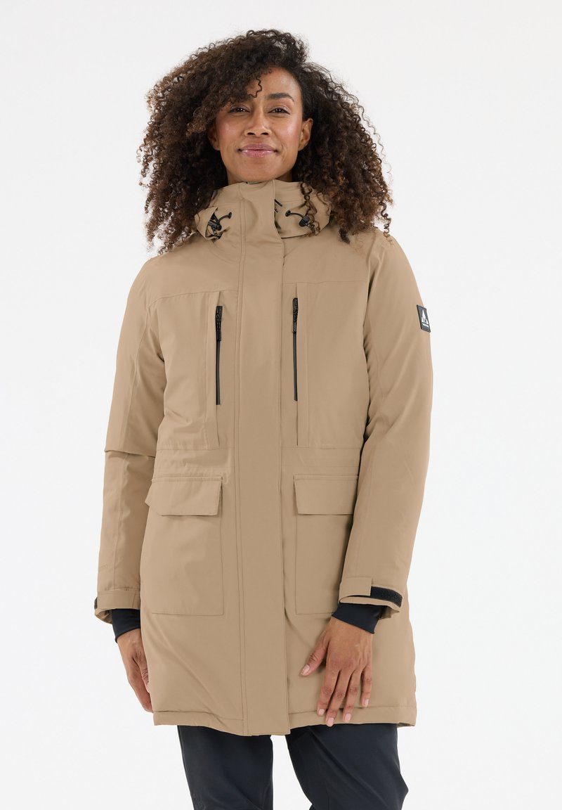 Beige eristetty parka, jossa on korkea kaulus, kaksi etutaskua ja vetoketjukiinnitys. Sisältää kiristysnauhan hupun ja pehmeän tekstuurin.