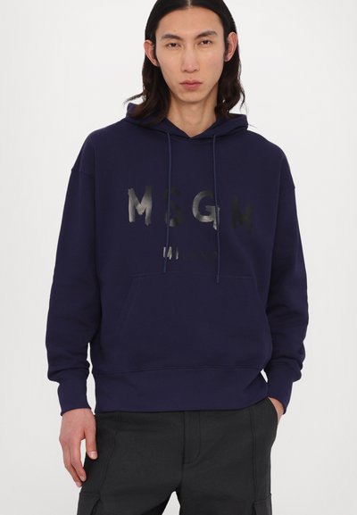 Felpa in cotone blu navy con tasca a scomparsa sul davanti e cordoncino. Presenta una stampa del logo in argento metallico. Polsini e orlo a costine.
