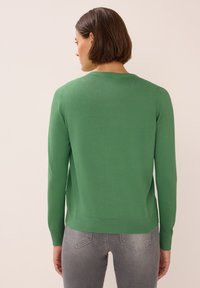 Zelený pletený cardigan s dlouhými rukávy, kulatým výstřihem a žebrovaným lemem. Hladká textura, přiléhavý design a minimální detaily.