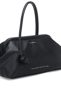 Borsa in pelle nera con due manici lunghi, dettaglio a nodo e testo in rilievo: "Ero una bottiglia, ora sono la tua borsa." Texture liscia.