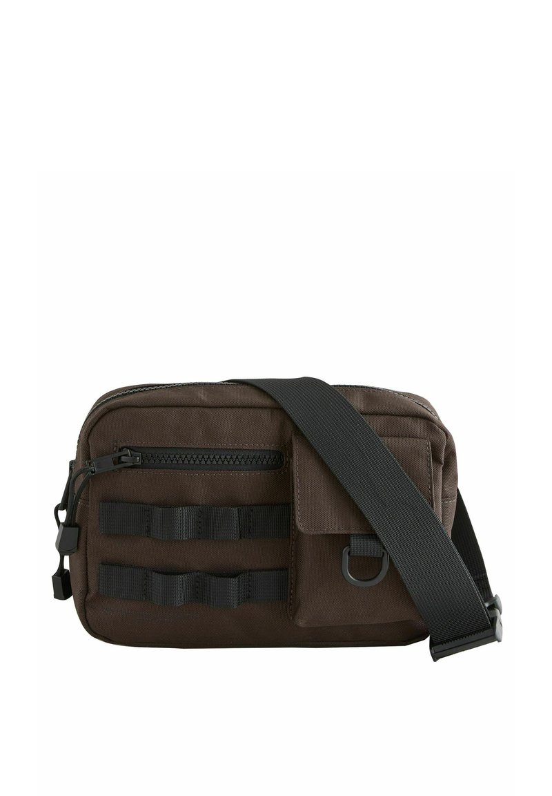 Bolsa mensajera de tela marrón con un bolsillo con cremallera, correa y acentos de cintas horizontales en la parte frontal para accesorios. Textura suave.