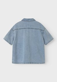 Svetlo modra denim srajca s kratkimi rokavi in ovratnikom, z vidnimi šivi ob šivih in sproščenim krojem. Prikazan zadnji pogled.