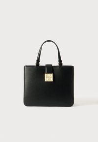 Sac à main en cuir noir avec double poignées, forme rectangulaire structurée, quincaillerie dorée, présentant un détail de fermoir en forme de logo carré.