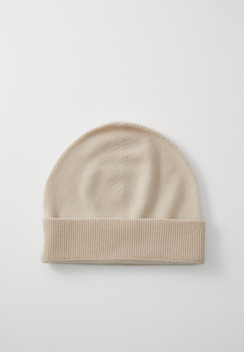 Beige knit beanie made of soft material, featuring a smooth, rounded top and a ribbed folded cuff for a snug fit.
