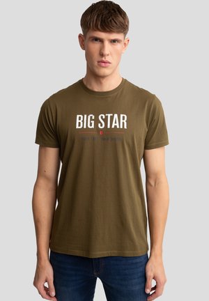 Alyvos žalios spalvos medvilninis marškinėliais su apvalia apykakle, ant kurių spausdintas "BIG STAR" baltos spalvos ir šūkis mažesnėmis raidėmis žemiau. Trumpomis rankovėmis, laisvas kirpimas.