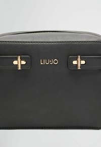 Černá kožená taška s pozlacenými kovovými prvky, značkovým logem "LIU JO" a strukturovaným designem s hladkou texturou.
